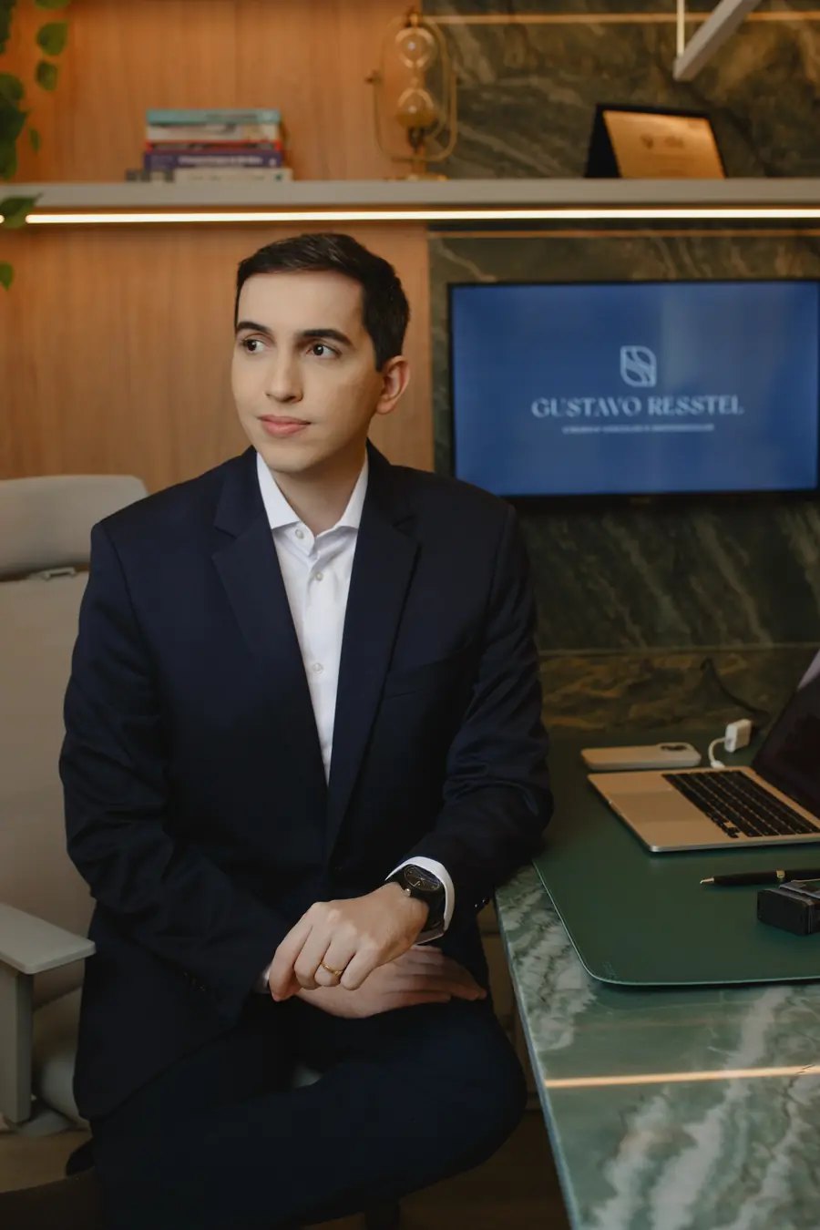 Dr. Gustavo Resstel sentado à mesa do consultório